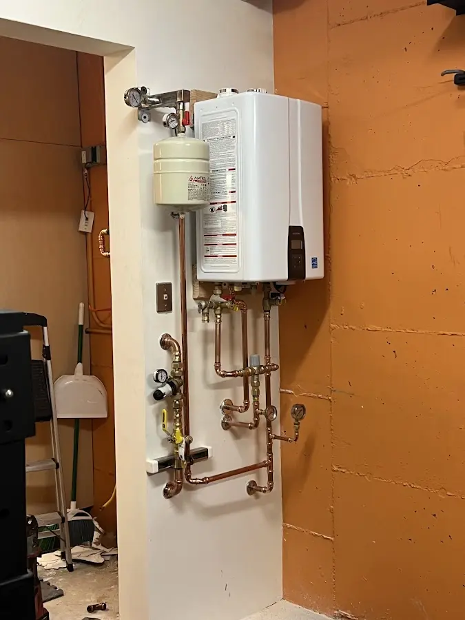 Plumbing technician inspecting water heater connections in Dubuque